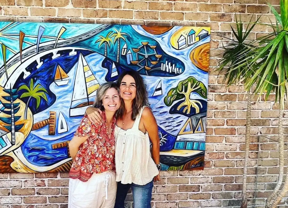 Mayor Amber Kearns with artist Emma Blyth in front of a colourful painting 